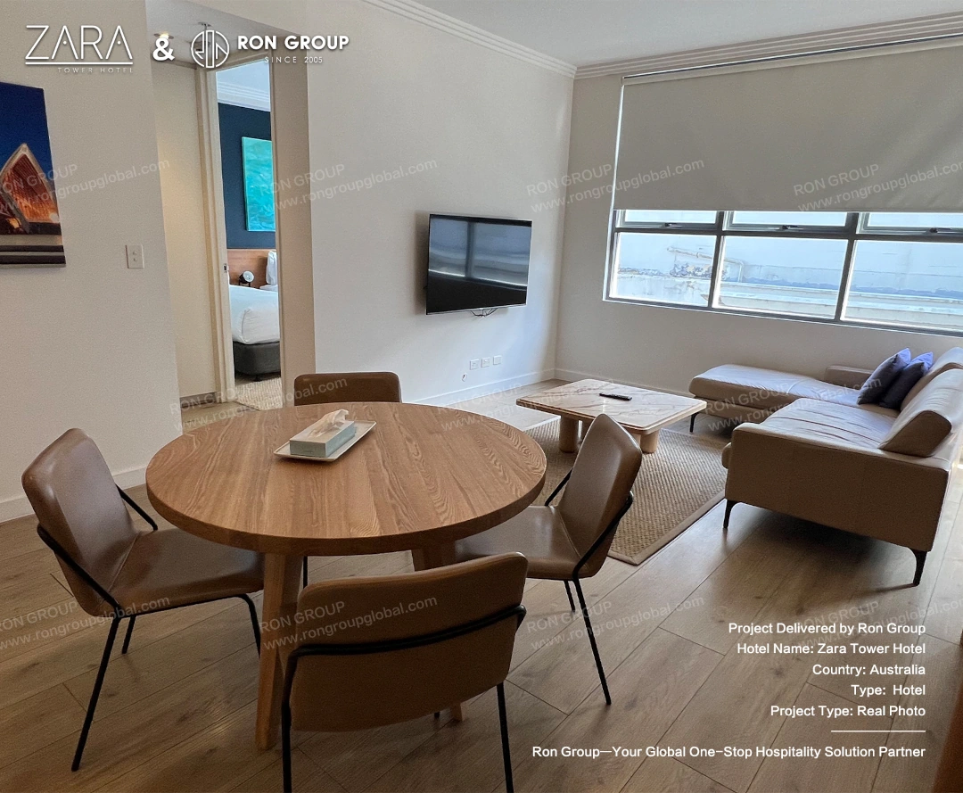 A bright modern living area with a leather sectional sofa and marble coffee table overlooking the city.