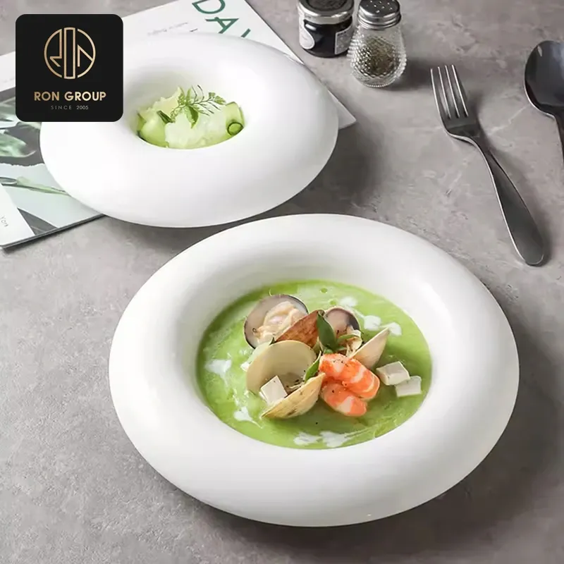 Deep porcelain soup and pasta plate engineered with curved well and sauce splash barrier