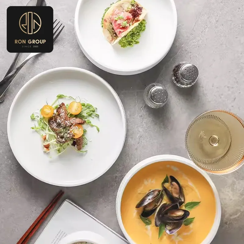 High-durability commercial porcelain plates stacked in a high-efficiency kitchen pass